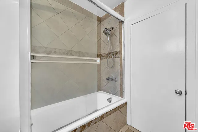 a view of an empty room with wooden floor and a ceiling fan