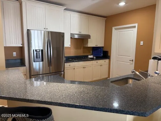 a kitchen with stainless steel appliances granite countertop a sink stove and refrigerator