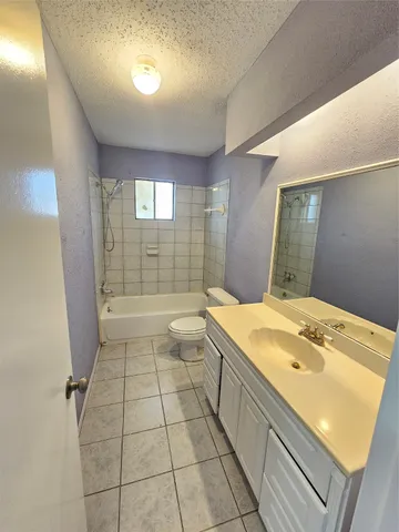 a backyard of a house with table and chairs plants and large tree