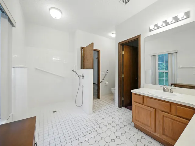 a spacious bathroom with a sink and a mirror
