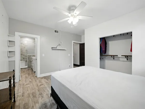 a open white kitchen with cabinets and wooden floor