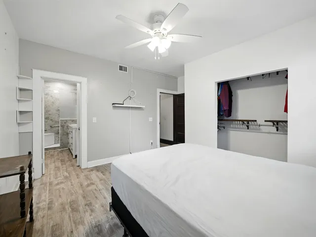 a open white kitchen with cabinets and wooden floor