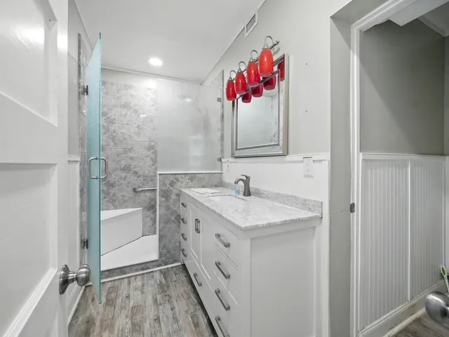 a bathroom with a sink vanity mirror and shower