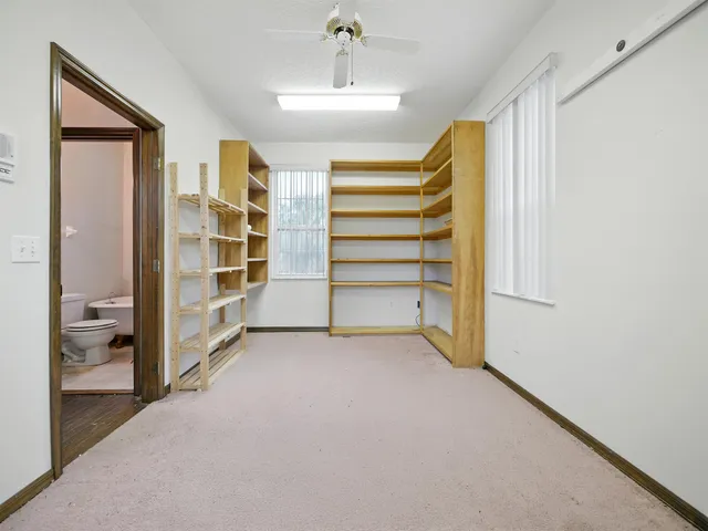 a view of room with balcony and a ceiling fan