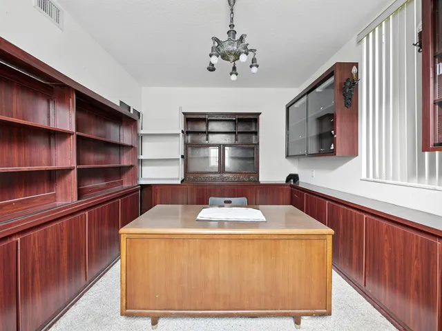 a dining room with wooden floor and large window