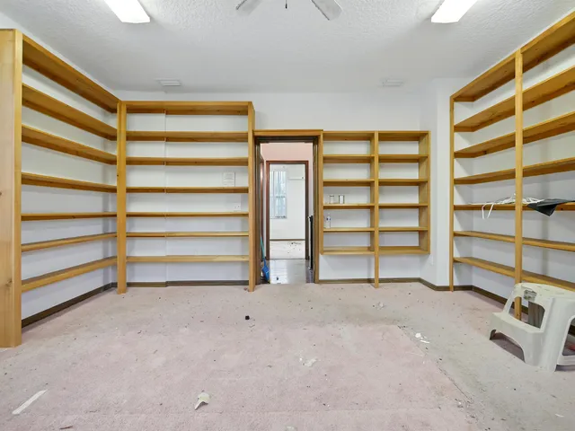 a view of room with walk in closet and empty racks
