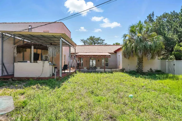 a view of a house with backyard and sitting area
