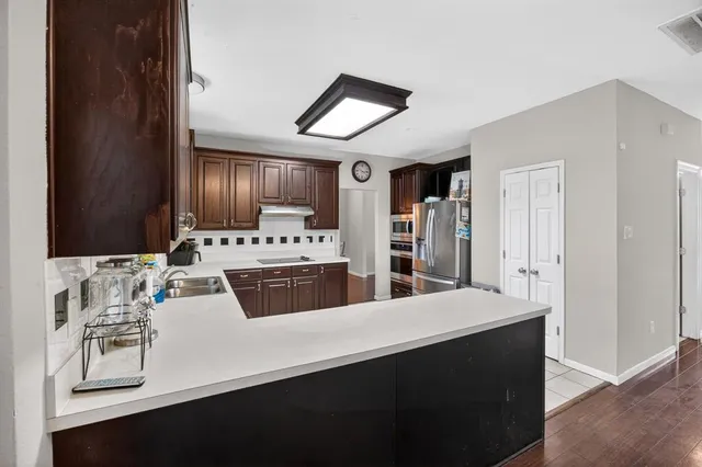 a kitchen with stainless steel appliances a sink and a refrigerator