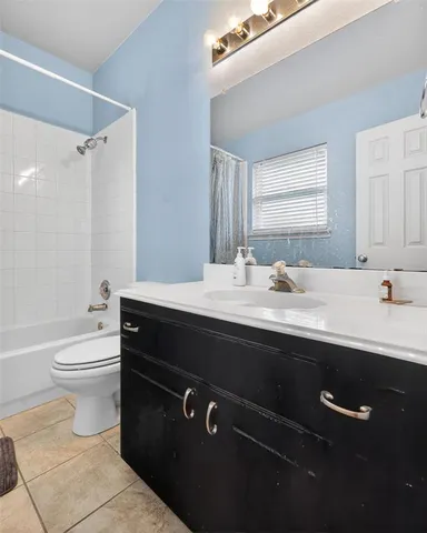 a bathroom with a sink a toilet a mirror and shower