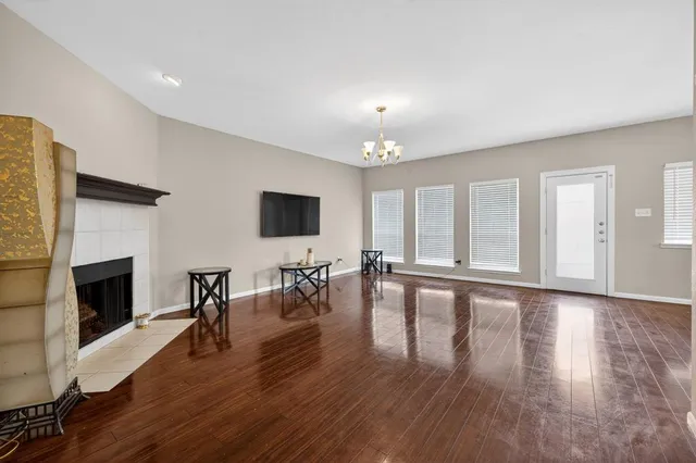 a view of a livingroom with wooden floor and a fireplace