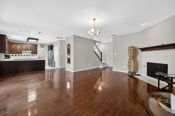 a view of a livingroom with furniture wooden floor and a kitchen