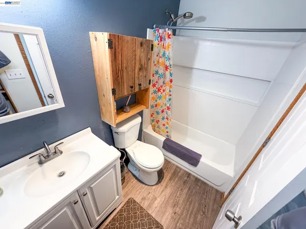 a bedroom with a bed and a mirror on the dresser