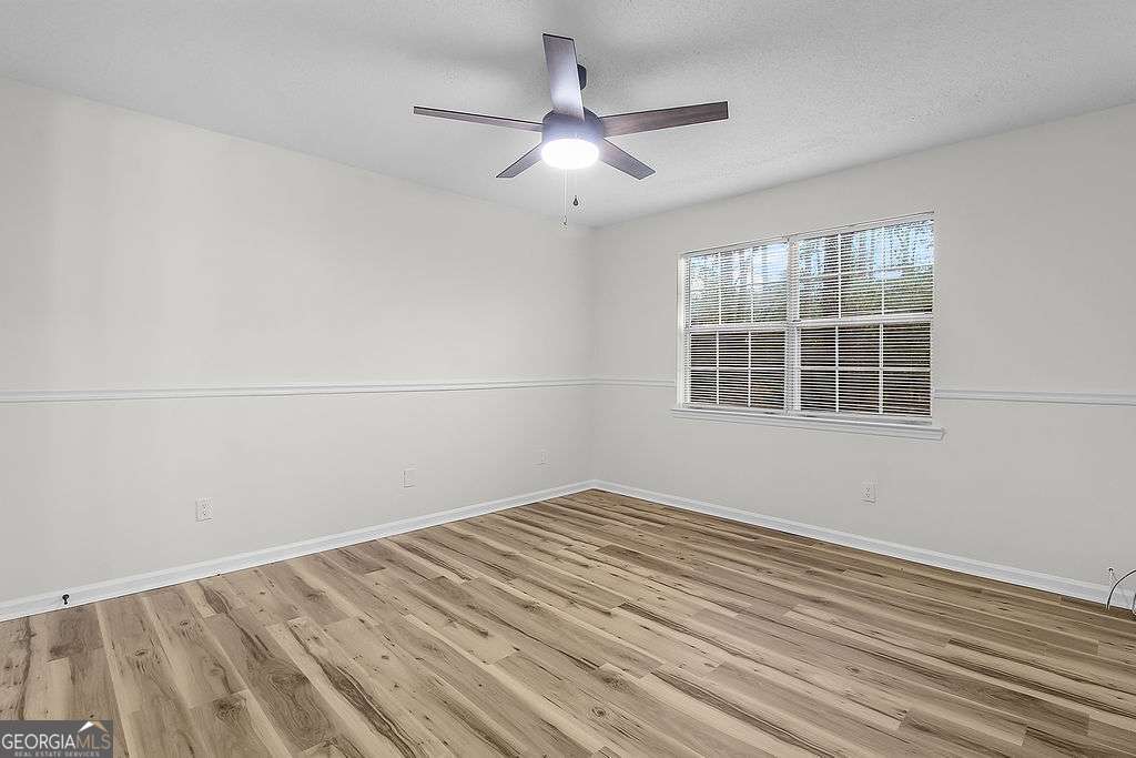 804 Ridgewood Way Hinesville, GA 31313 - Photo 18 of 27 a view of empty room with wooden floor and fan