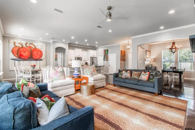 a living room with furniture kitchen view and a large window