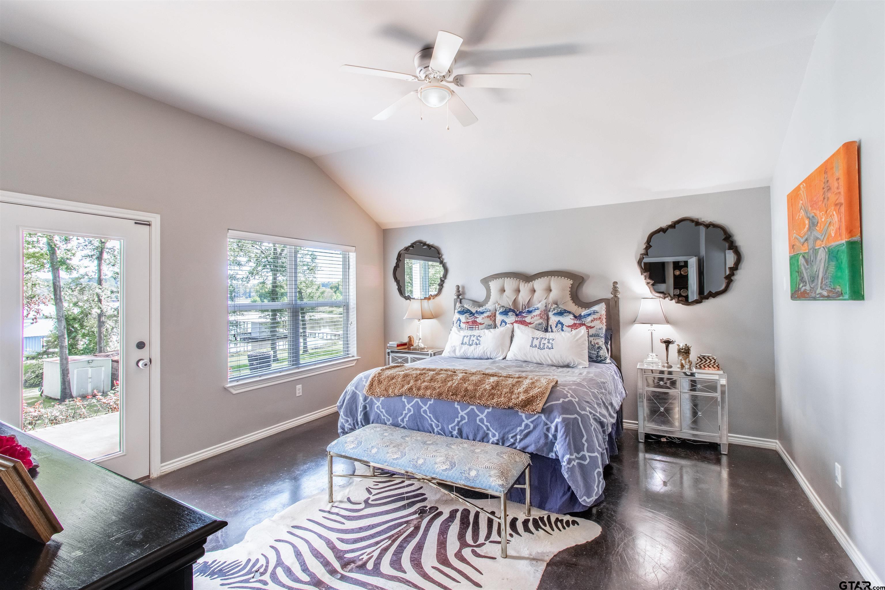 14271 NW Road Tyler, TX 75707 - Photo 23 of 48 a bedroom with a bed a mirror and a large window with wooden floor