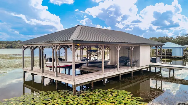 a view of a patio with couches table and chairs under an umbrella
