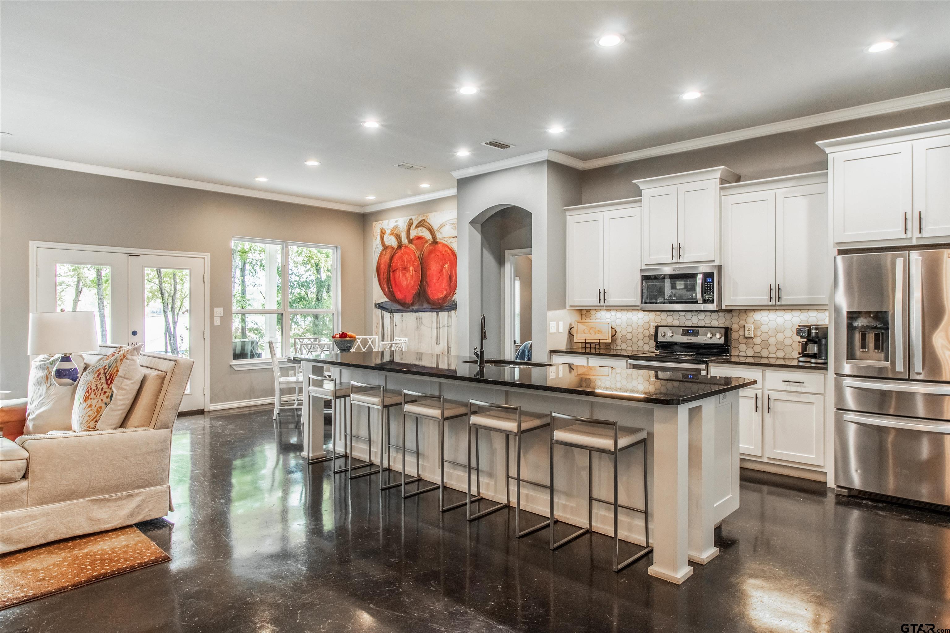 14271 NW Road Tyler, TX 75707 - Photo 4 of 48 a kitchen with stainless steel appliances granite countertop a stove top oven a sink dishwasher a dining table and chairs with wooden floor
