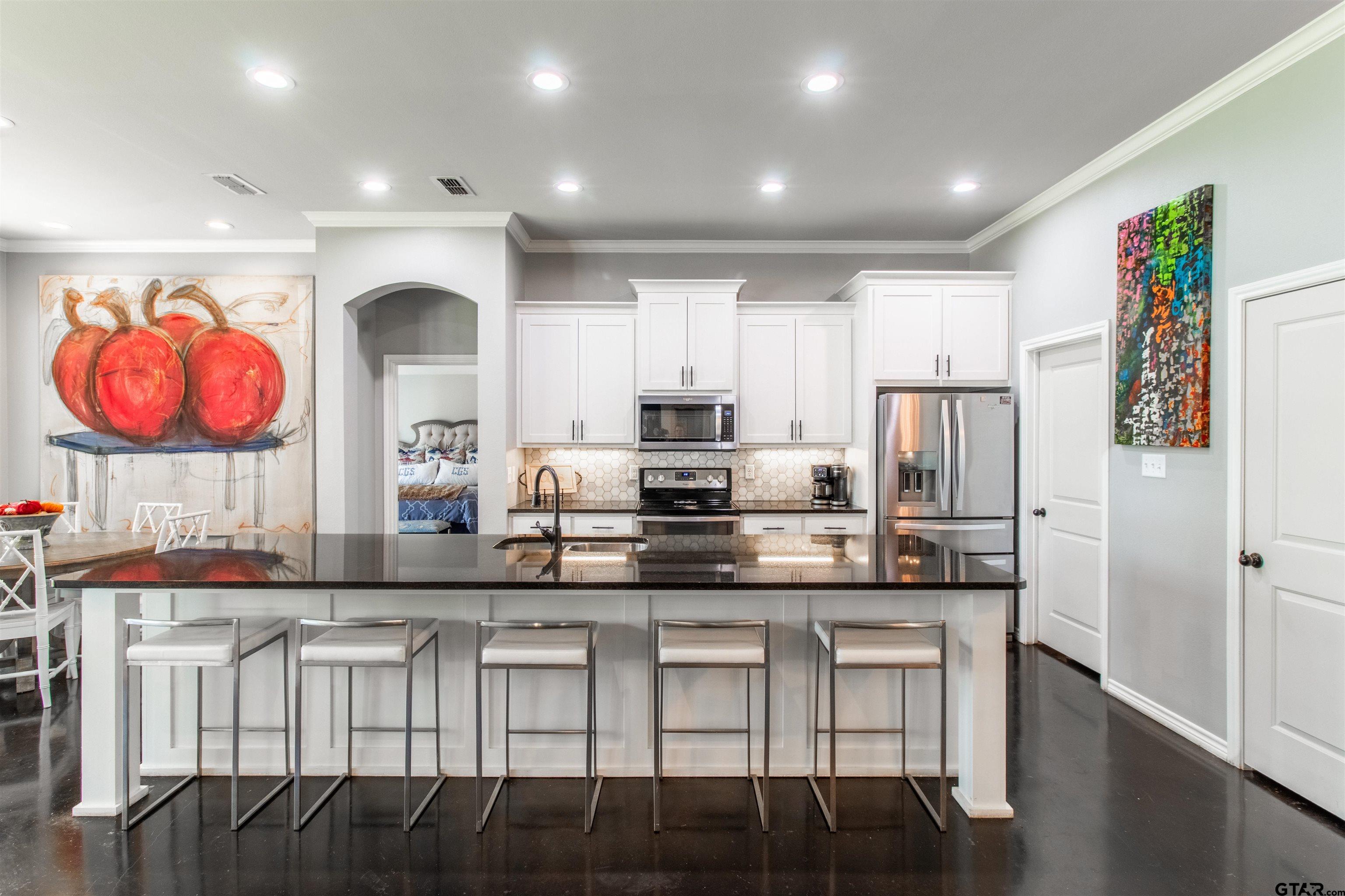 14271 NW Road Tyler, TX 75707 - Photo 5 of 48 a kitchen with kitchen island granite countertop a stove a sink and a refrigerator