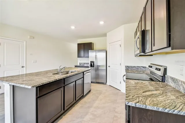 a kitchen with stainless steel appliances granite countertop a sink and a stove