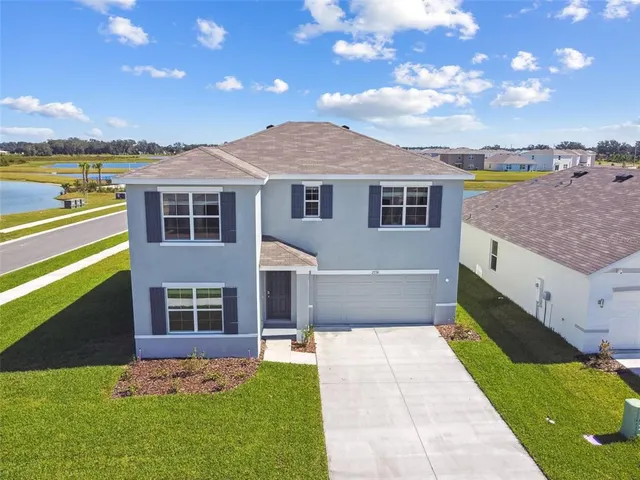an aerial view of a house with a swimming pool and outdoor seating