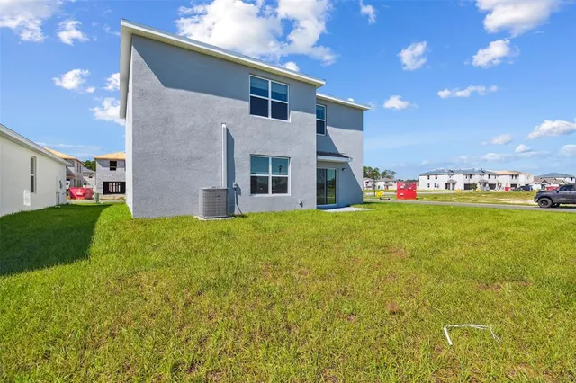 a view of a house with a big yard and large tree