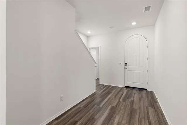 a view of a room with wooden floor and white walls