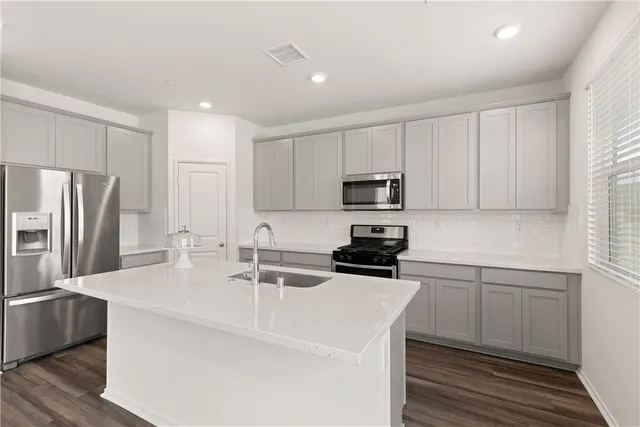 a kitchen with a sink cabinets and stainless steel appliances