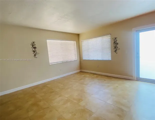 a view of a refrigerator in kitchen and a window