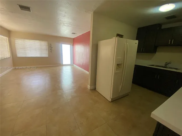 a kitchen with refrigerator and cabinets