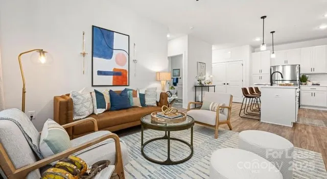 a living room with furniture kitchen view and a chandelier