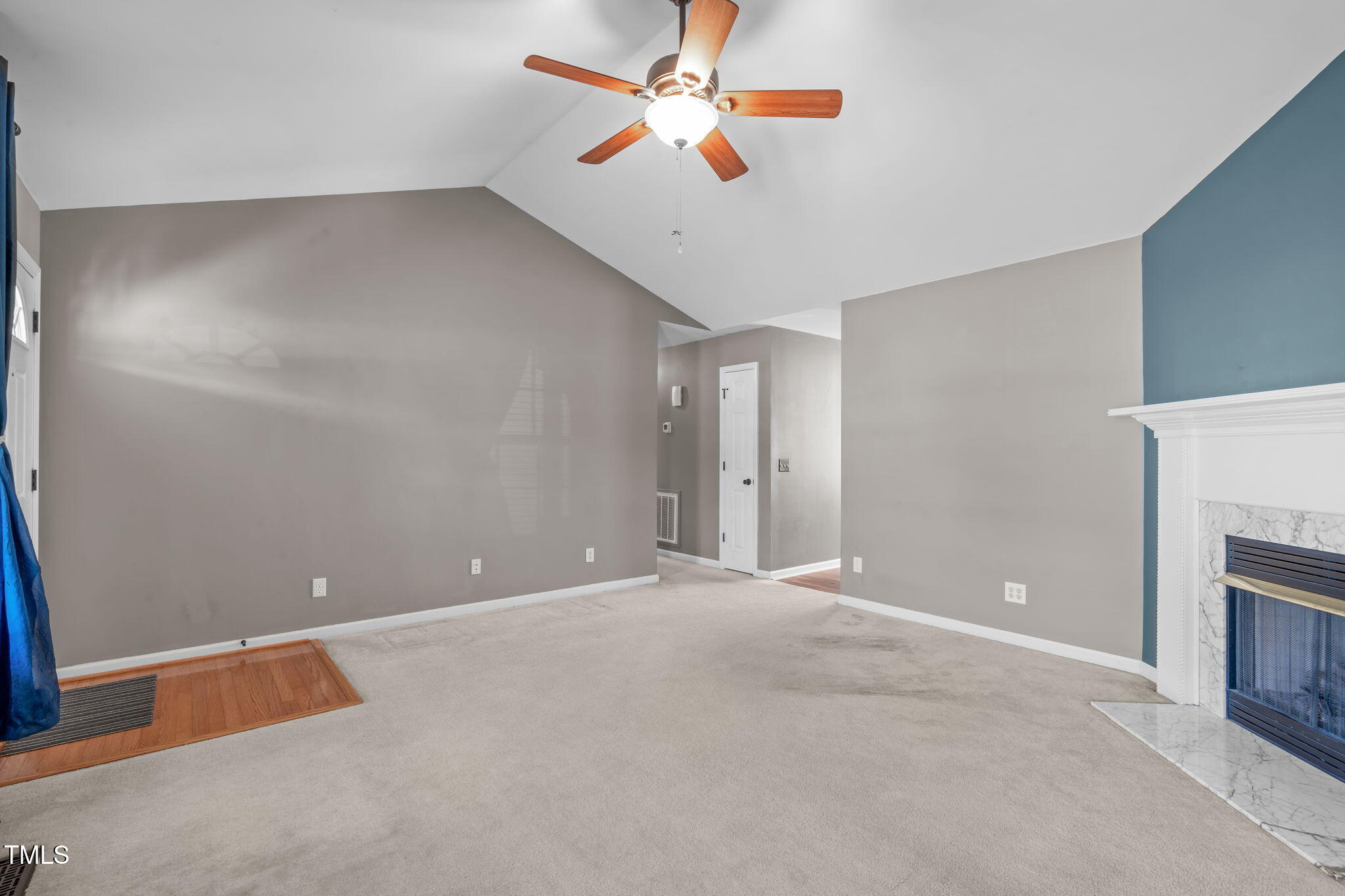 7905 Willow Croft Drive Willow Spring, NC 27592 - Photo 5 of 26 a view of an empty room with a ceiling fan and a fireplace