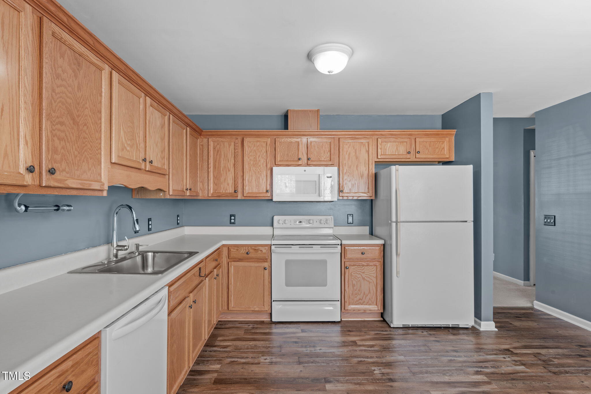 7905 Willow Croft Drive Willow Spring, NC 27592 - Photo 7 of 26 a kitchen with a white cabinets and white appliances