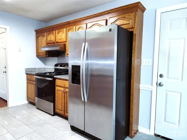 a kitchen with stainless steel appliances granite countertop a refrigerator and a stove