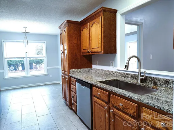 a kitchen with granite countertop a sink and a stove