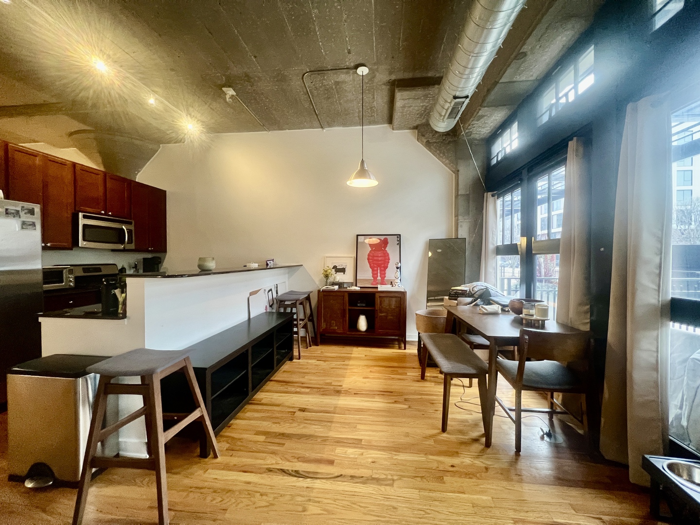 1151 West 15th Street, Unit 137 Chicago, IL 60608 - Photo 7 of 27 a dining room with stainless steel appliances kitchen island granite countertop a table chairs and a refrigerator