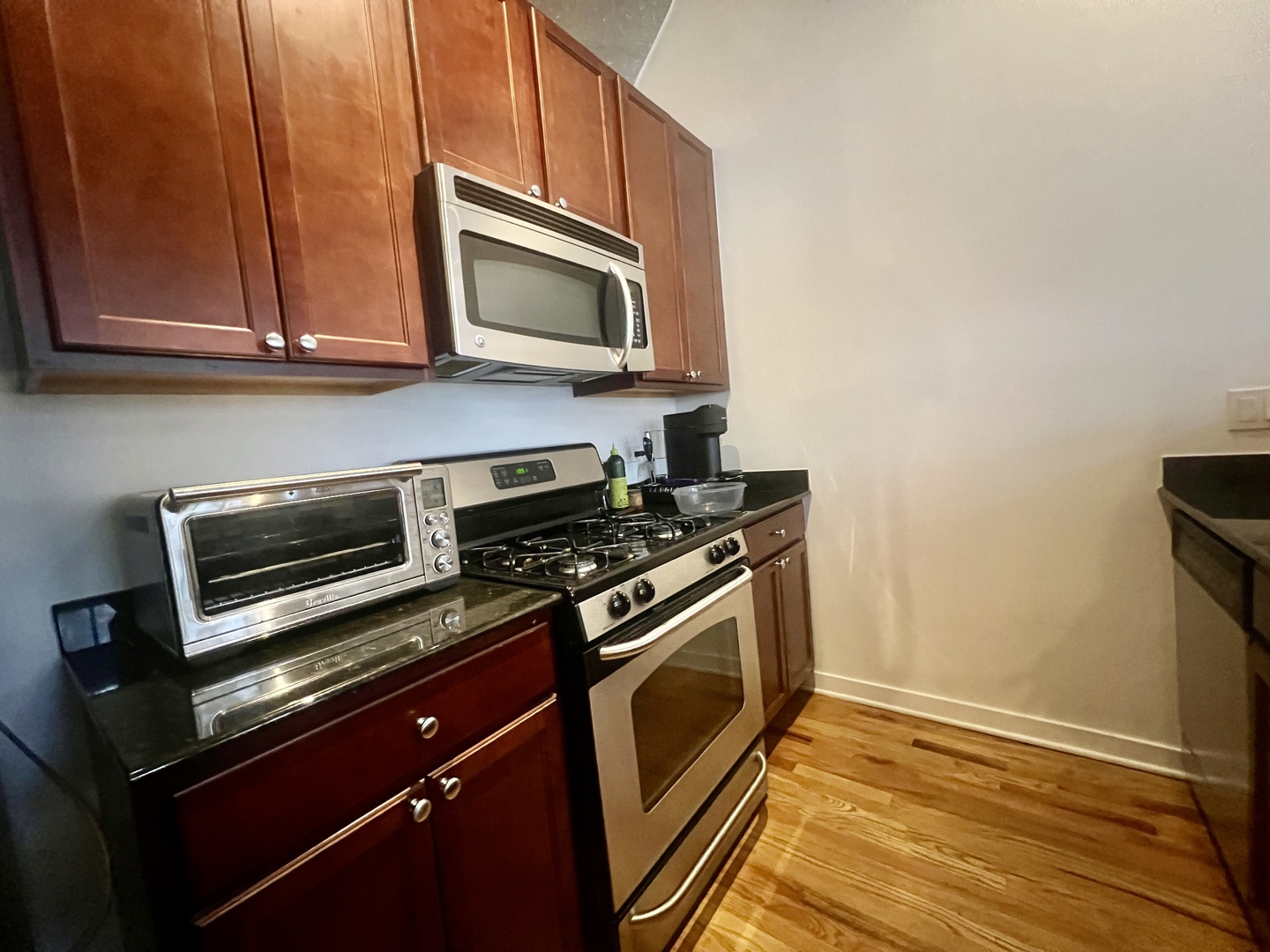 1151 West 15th Street, Unit 137 Chicago, IL 60608 - Photo 9 of 27 a kitchen with granite countertop cabinets and steel stainless steel appliances