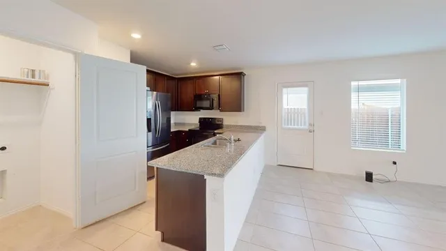 a kitchen with stainless steel appliances a refrigerator and a stove top oven