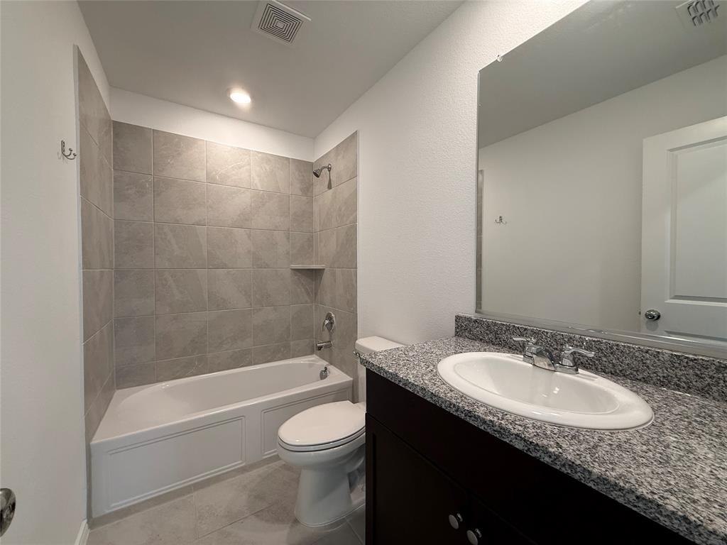 5970 Wedgemere Drive Princeton, TX 75407 - Photo 12 of 17 a bathroom with a granite countertop sink a toilet and shower