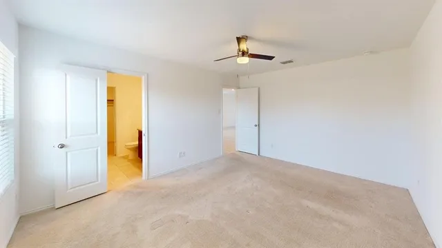 an empty room with a ceiling fan and a window