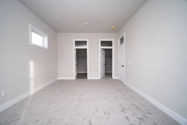 an empty room with closet and windows