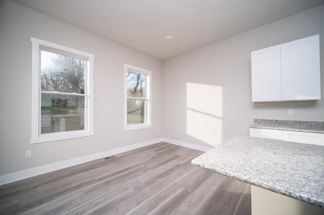 a view of a kitchen with wooden floor and a window
