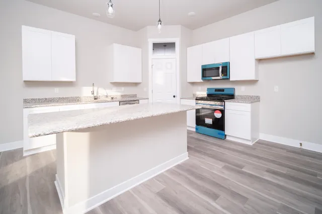 a kitchen with stainless steel appliances granite countertop a sink a stove and cabinets