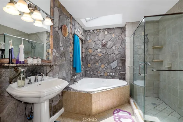 a bathroom with a sink a toilet a mirror and shower