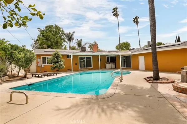 a view of a house with backyard and sitting area