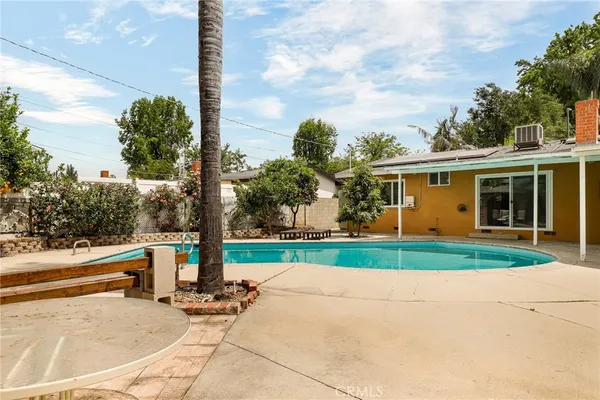 a view of a house with a yard and large tree