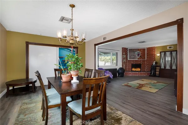 a dining room with furniture a chandelier and wooden floor