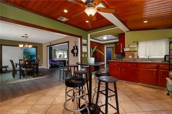 a kitchen with stainless steel appliances granite countertop table chairs and a large window