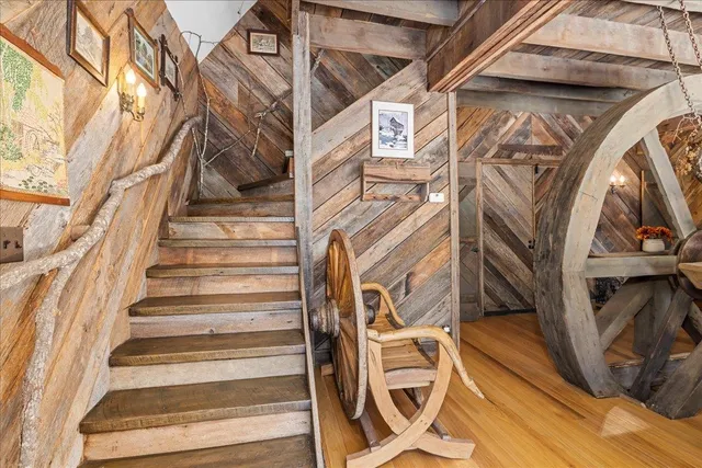 a view of a brick house next to a yard with large trees