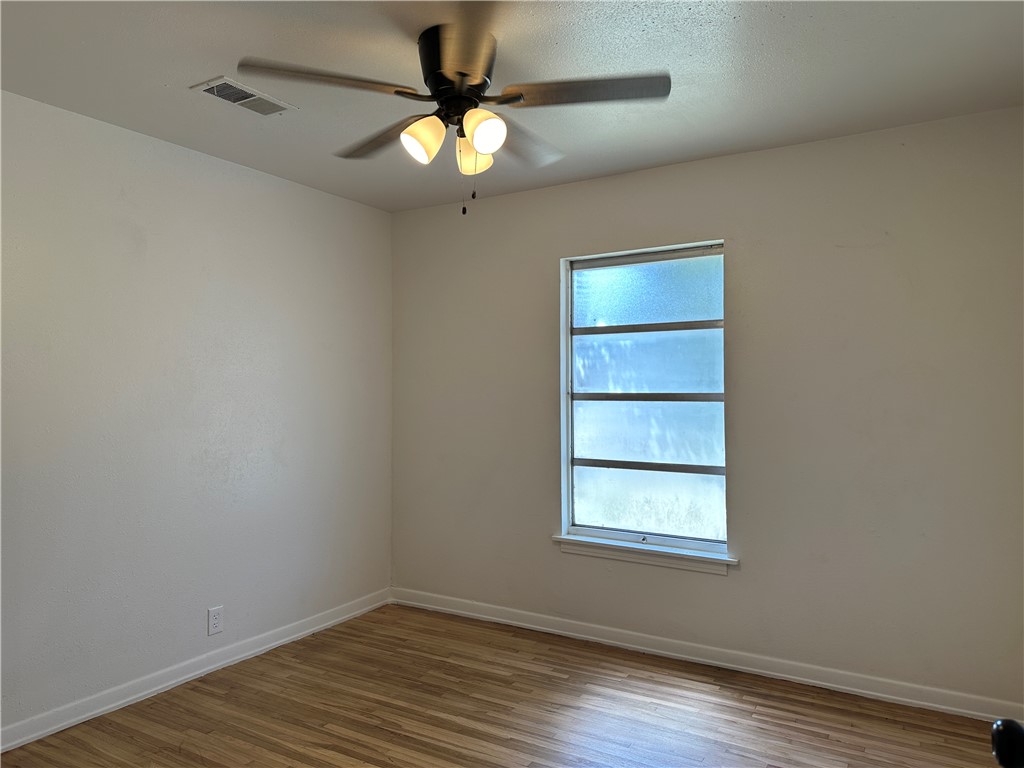 4814 Jean Street Corpus Christi, TX 78411 - Photo 11 of 11 an empty room with wooden floor fan and windows