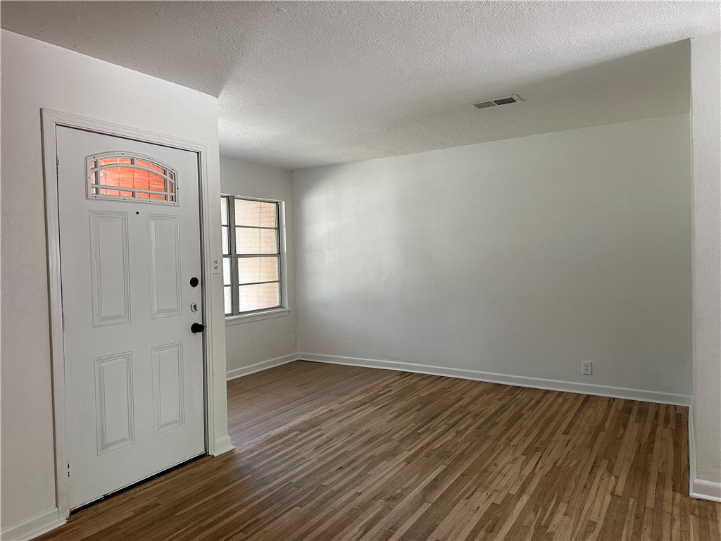 4814 Jean Street Corpus Christi, TX 78411 - Photo 3 of 11 wooden floor in an empty room with a window